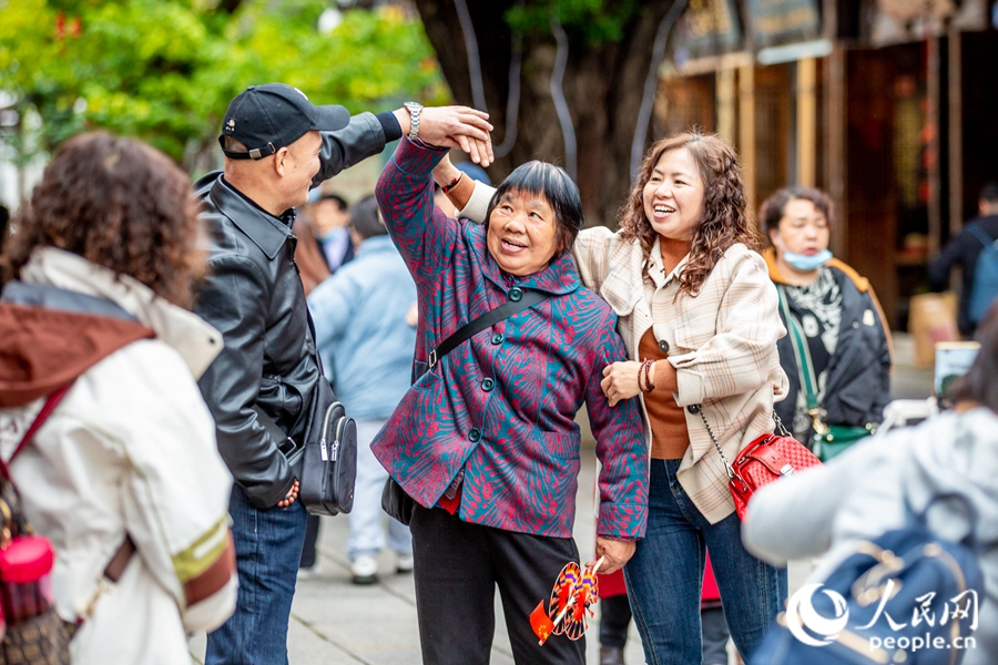 三坊七巷中，中年夫婦在網(wǎng)紅“愛心樹”前學習“比心”姿勢?？道跀z