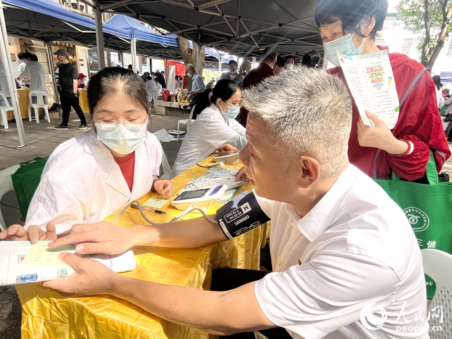 一位市民在展位前測量血壓。人民網(wǎng) 錢嘉禾攝