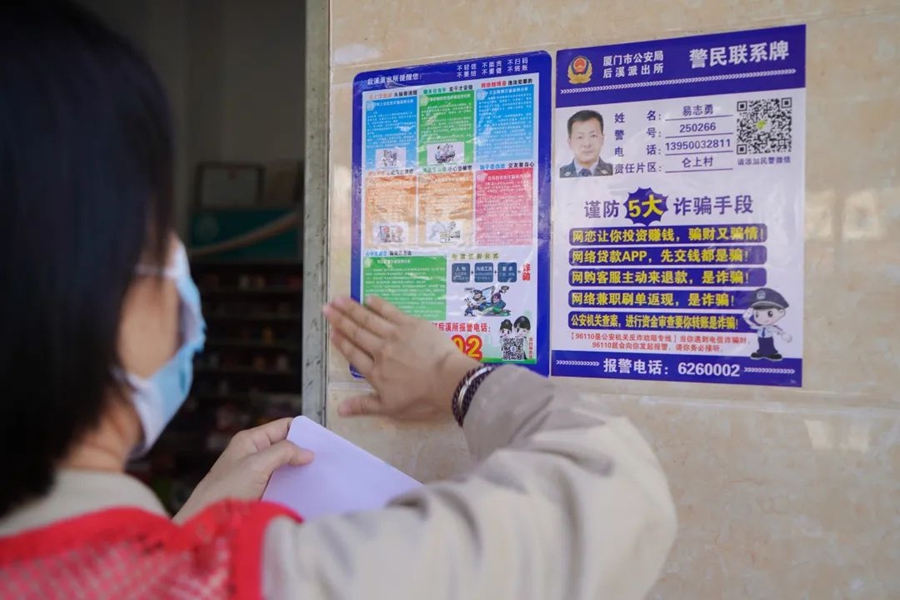 社區(qū)工作者張貼反詐宣傳單。集美區(qū)融媒體中心供圖