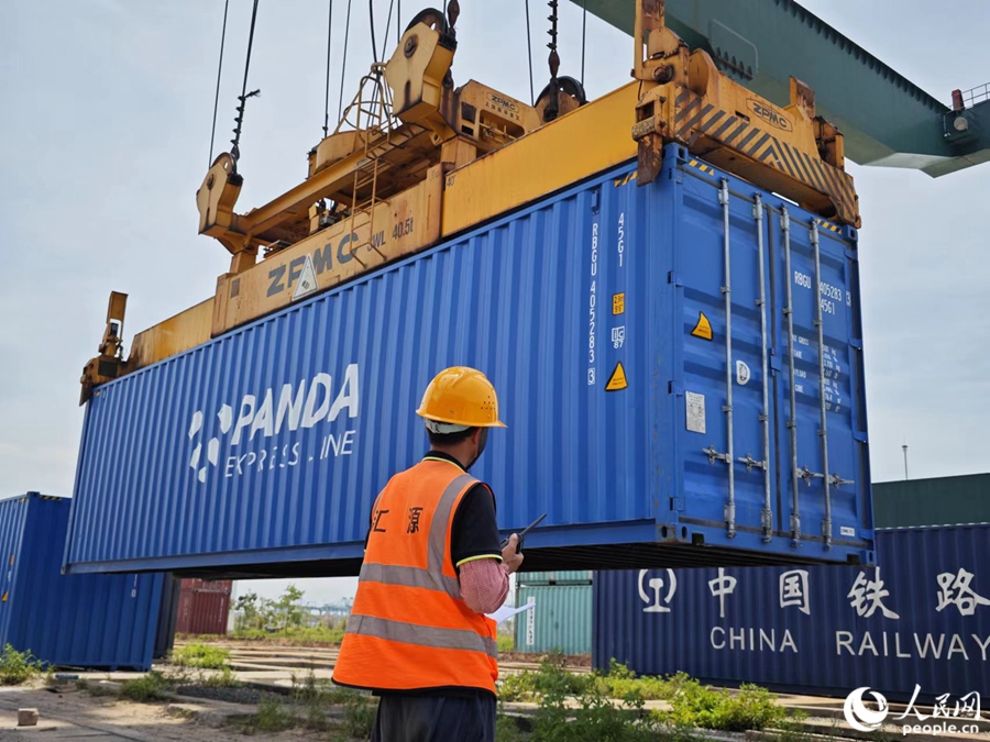 工作人員指揮門式起重機吊運貨柜。人民網 黃東儀攝