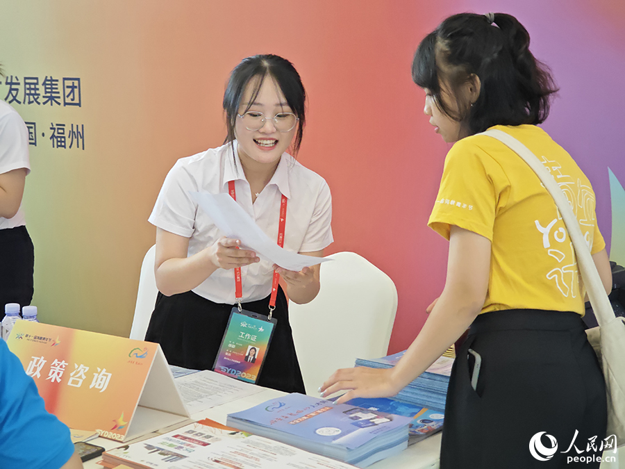 8月10日，“好年華·聚福州”2023年閩臺(tái)青年人才研學(xué)營(yíng)招聘會(huì)上，工作人員熱情地向臺(tái)灣青年介紹福州市為便利臺(tái)灣青年來(lái)榕就業(yè)創(chuàng)業(yè)出臺(tái)的優(yōu)惠政策。人民網(wǎng) 黃東儀攝