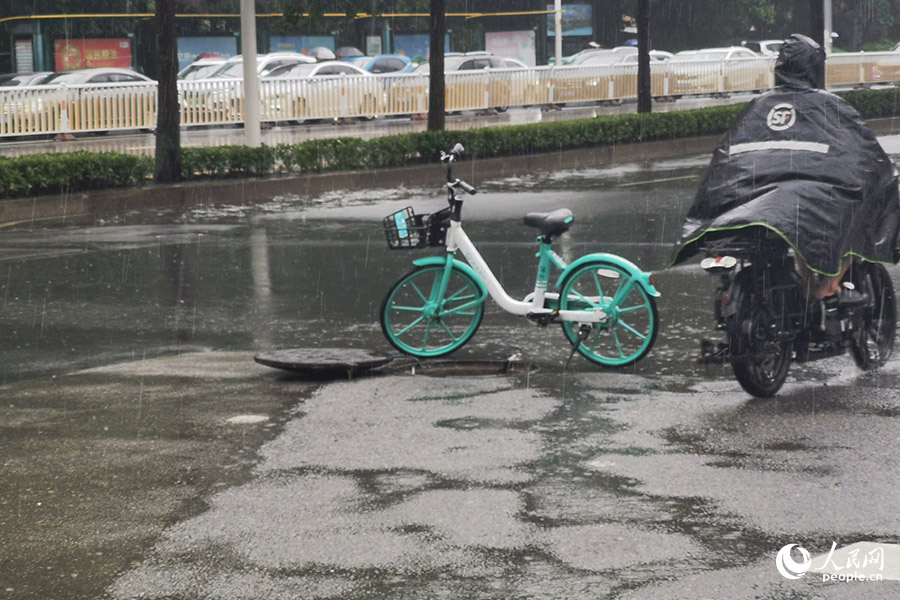 一處開(kāi)井蓋排水，用共享單車(chē)提示行人。人民網(wǎng)記者 林曉麗攝