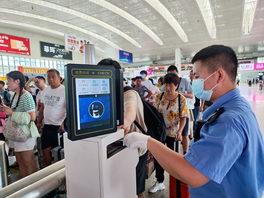 工作人員引導(dǎo)旅客檢票進(jìn)站。韓毅攝