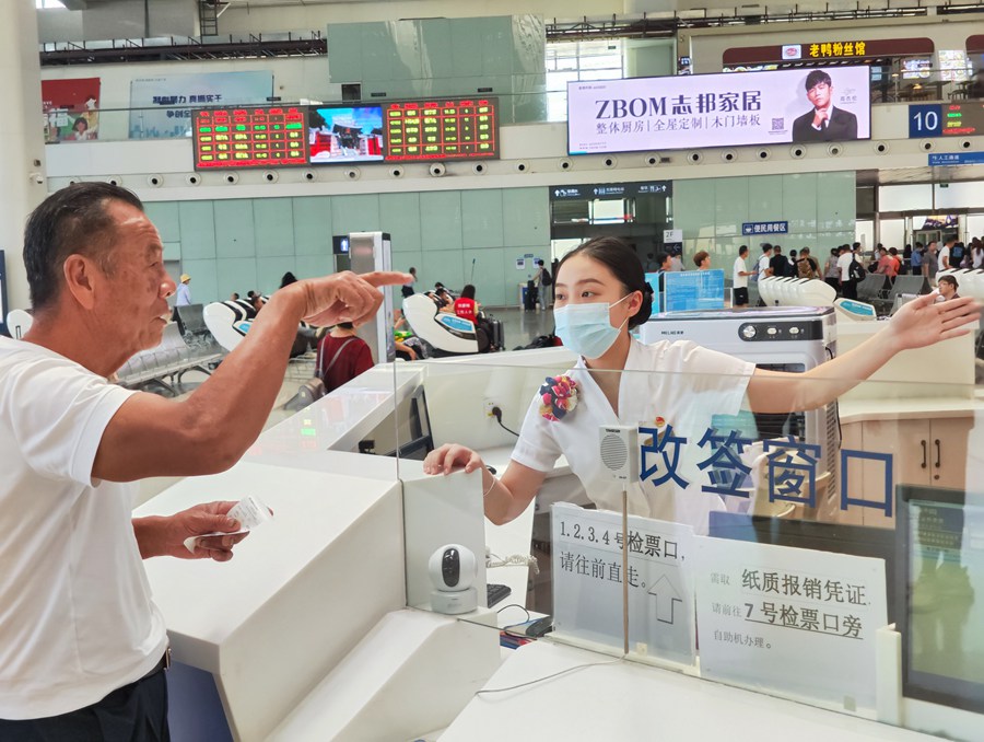 服務(wù)臺工作人員為旅客解答咨詢。韓毅攝