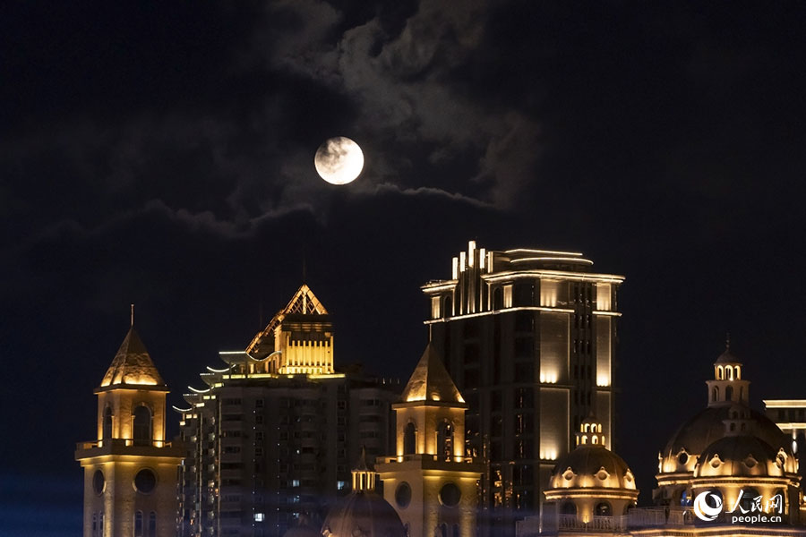9月29日18時28分，一輪明月“羞答答”地從云中露出，在福建福州”閩江之心“上空升起。人民網記者 蘭志飛攝