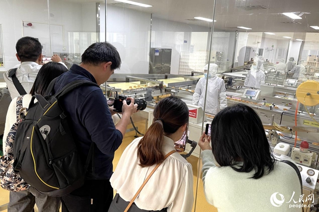 參賽記者參訪盼盼食品有限公司生產(chǎn)車間，拍攝取材。人民網(wǎng) 謝星宇攝