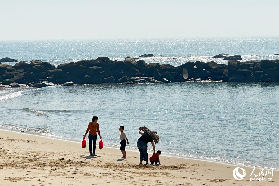 12月9日，泉州石獅市“十里黃金海岸”海邊，游客流連忘返。人民網(wǎng)記者 劉卿攝