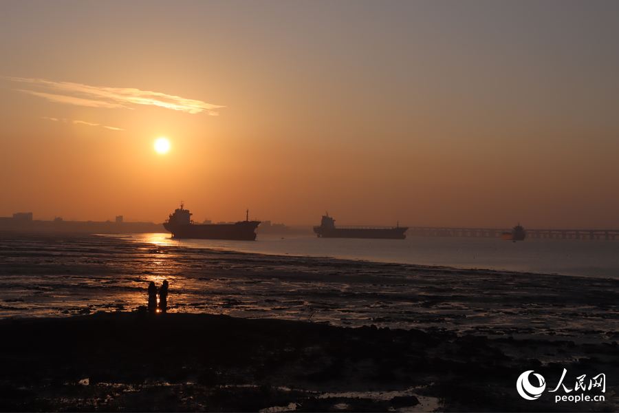 12月9日傍晚，在泉州石獅市石湖碼頭，游客們欣賞海邊落日。人民網(wǎng)記者 劉卿攝