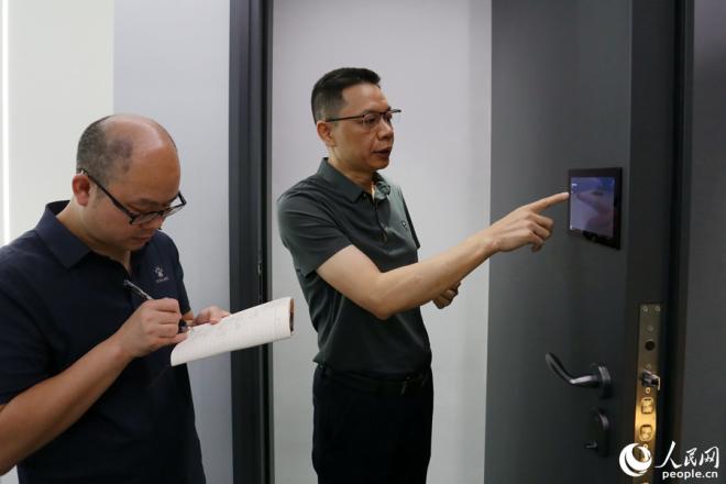 施米德科技負(fù)責(zé)人正在介紹一款創(chuàng)新型智能門(mén)。人民網(wǎng)記者 陳博攝