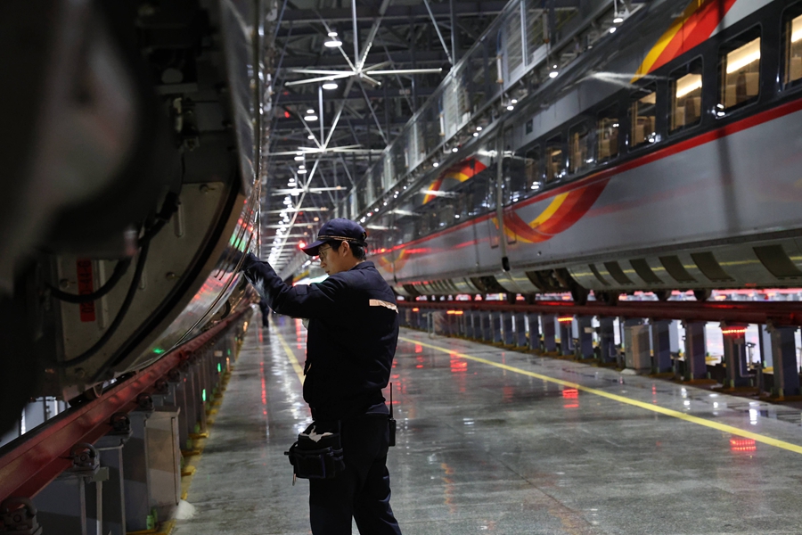 動(dòng)車組機(jī)械師正在對車組兩側(cè)進(jìn)行檢查。 譚文卿攝