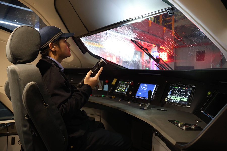 動(dòng)車組機(jī)械師正在對司機(jī)室遮陽簾進(jìn)行檢查。譚文卿攝