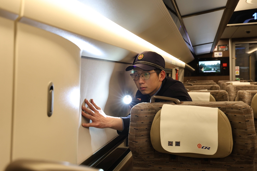 動(dòng)車組機(jī)械師正在對頭燈進(jìn)行確認(rèn)。  譚文卿攝