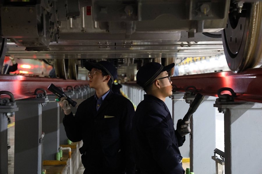 動(dòng)車組機(jī)械師正在對轉(zhuǎn)向架進(jìn)行檢查。譚文卿攝