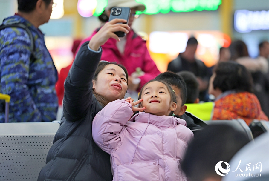 乘客在廈門(mén)北站候車(chē)室里合影，發(fā)送給遠(yuǎn)方的家人。人民網(wǎng)記者 陳博攝