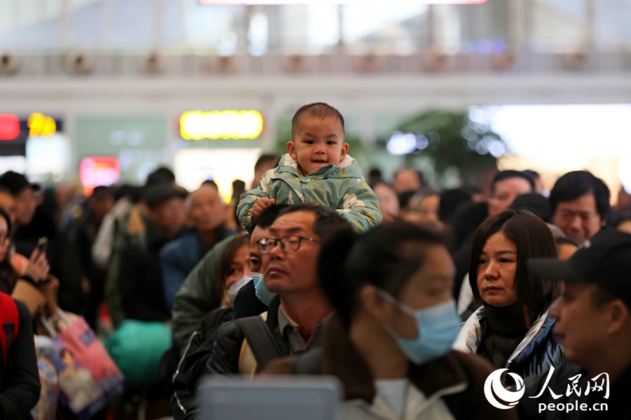 廈門(mén)北站候車(chē)閘口前排起長(zhǎng)隊(duì)，一位小乘客“登高遠(yuǎn)望”。人民網(wǎng)記者 陳博攝