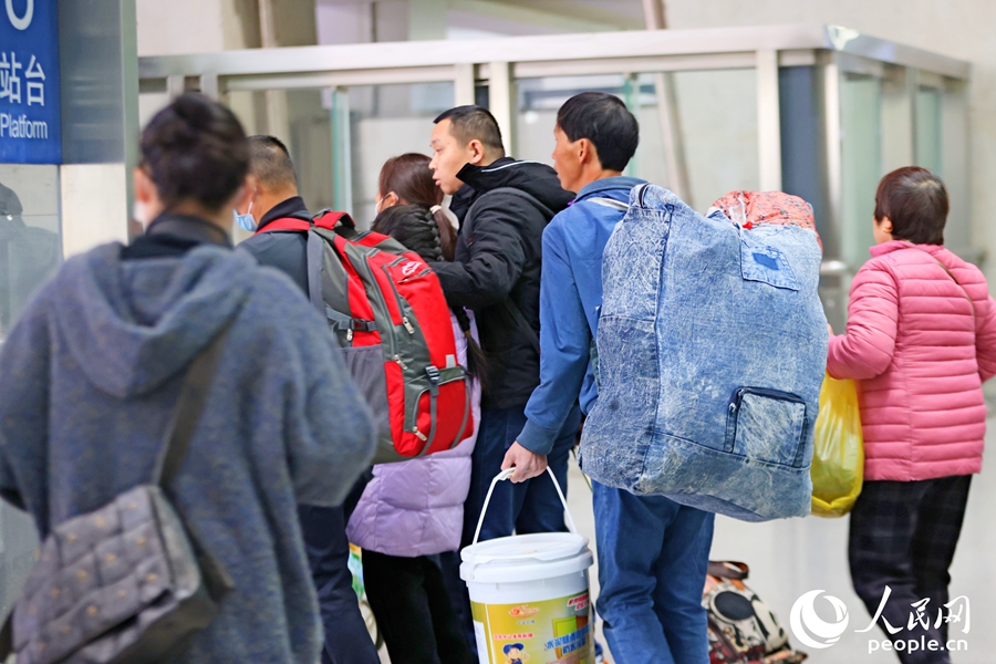 隨著列車(chē)駛?cè)霃B門(mén)北站，乘客們背著大包小包的行李奔向月臺(tái)，踏上新年回家路。人民網(wǎng)記者 陳博攝