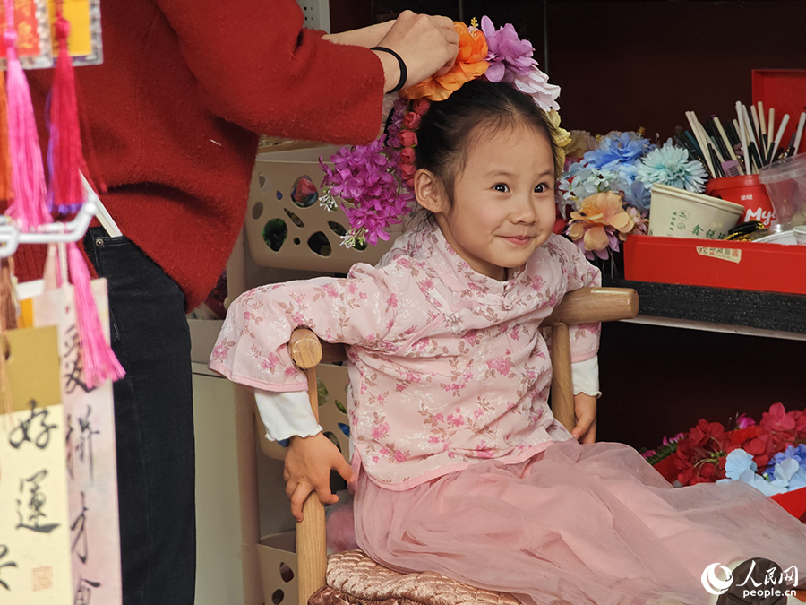 一個(gè)女孩正在體驗(yàn)“簪花”。人民網(wǎng) 黃東儀攝