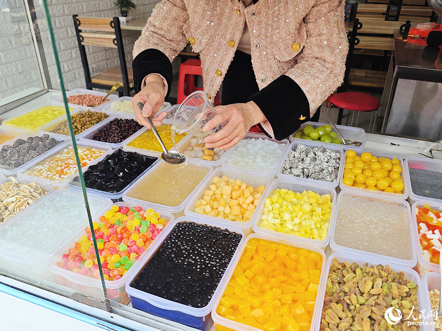 賣四果湯的老板娘正在調(diào)配飲料。人民網(wǎng) 黃東儀攝