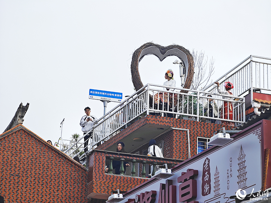 游客登上臨街天臺(tái)尋找最佳拍攝角度。人民網(wǎng) 黃東儀攝