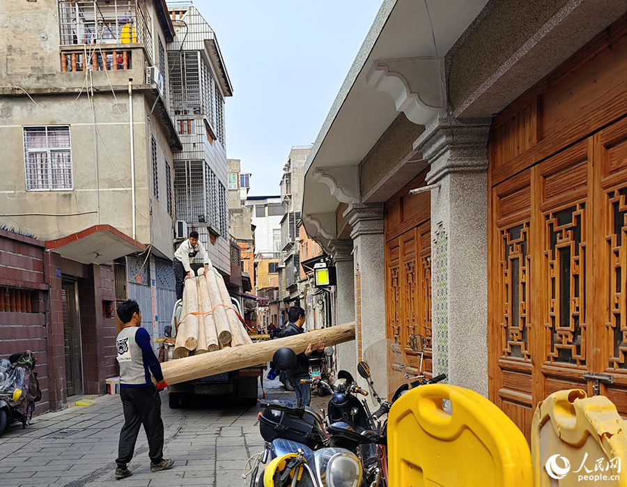 工作人員正在搬運(yùn)修復(fù)古民居所用的木料。人民網(wǎng) 黃東儀攝