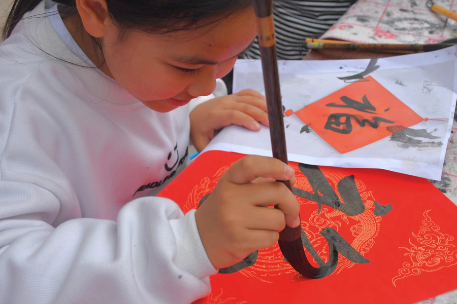在檳榔社區(qū)，小女孩拿起毛筆書寫“?！弊?。楊金木攝