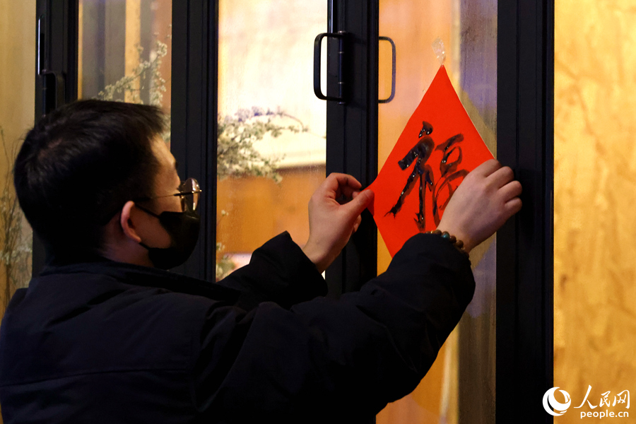 一位市民將DIY的“?！弊执郝?lián)貼在窗戶上。人民網(wǎng)記者 陳博攝