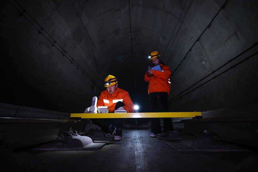 為了確保隧道內(nèi)接觸網(wǎng)設(shè)備參數(shù)符合標(biāo)準(zhǔn)，地面作業(yè)組每晚步行2公里，完成接觸網(wǎng)設(shè)備240多個(gè)定位點(diǎn)的測(cè)量工作。圖為99后女接觸網(wǎng)工堯佳（右一）和工友使用激光測(cè)量儀檢查接觸網(wǎng)的各項(xiàng)參數(shù)。胡鵬攝