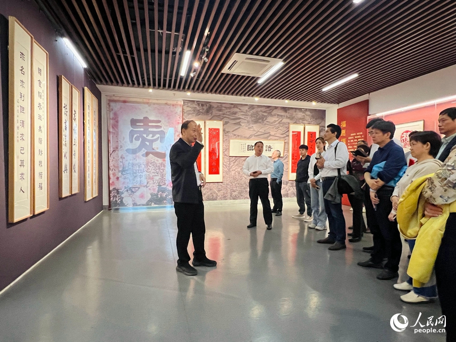 陳吉向市民游客介紹書法作品。人民網(wǎng) 陳歡歡攝