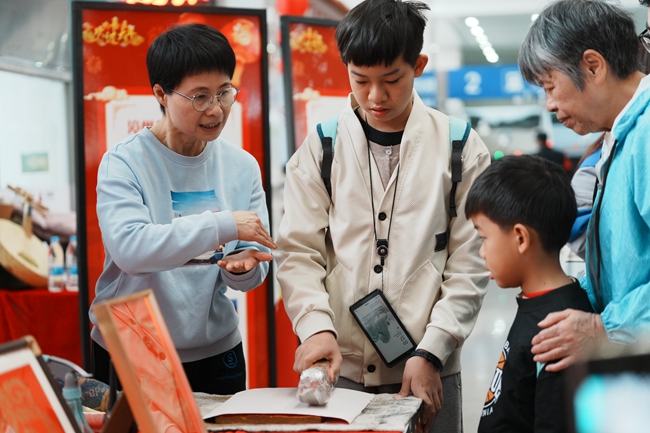 旅客朋友在漳州站文化圩市里體驗制作木版年畫。陳明 攝.jpg