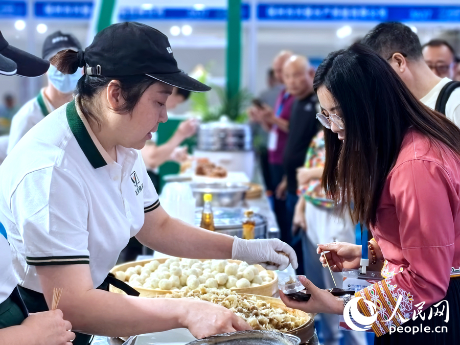 一位參展企業(yè)工作人員在向觀展者介紹產(chǎn)品。人民網(wǎng)記者 林曉麗攝