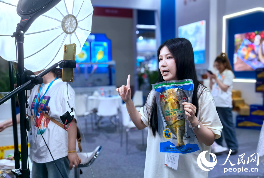 在展會上，有參展企業(yè)工作人員在通過直播推介產(chǎn)品。人民網(wǎng)記者 林曉麗攝