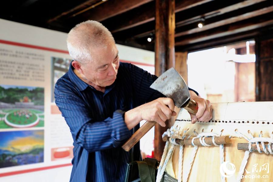 竹釘鼓制作技藝非遺傳承人彭招波將竹釘釘入鼓內(nèi)。人民網(wǎng) 李唯一攝