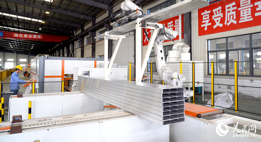 在鋁模板智能自動(dòng)化生產(chǎn)線(xiàn)上，機(jī)械臂在自動(dòng)投料。人民網(wǎng)記者 蘭志飛攝