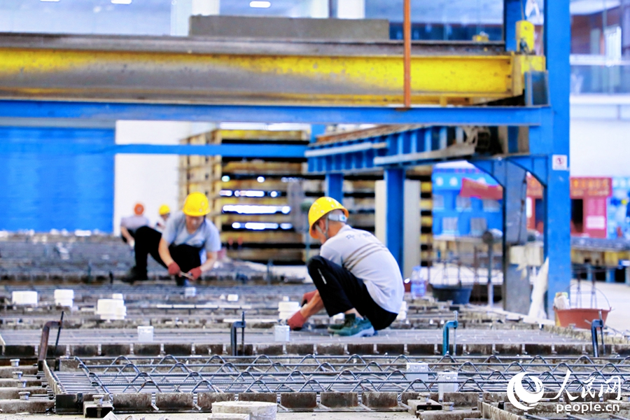 批量澆筑前，工人正在捆綁鋼筋。人民網(wǎng) 李唯一攝