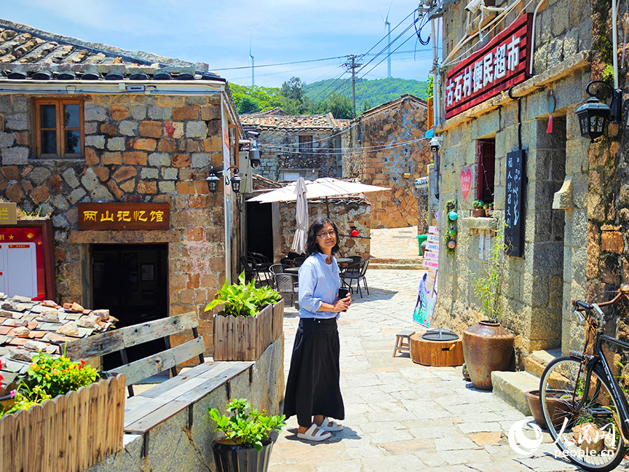 民宿主理人戴小姐（臺灣）站在文創(chuàng)空間外的石板路上。人民網(wǎng) 黃東儀攝