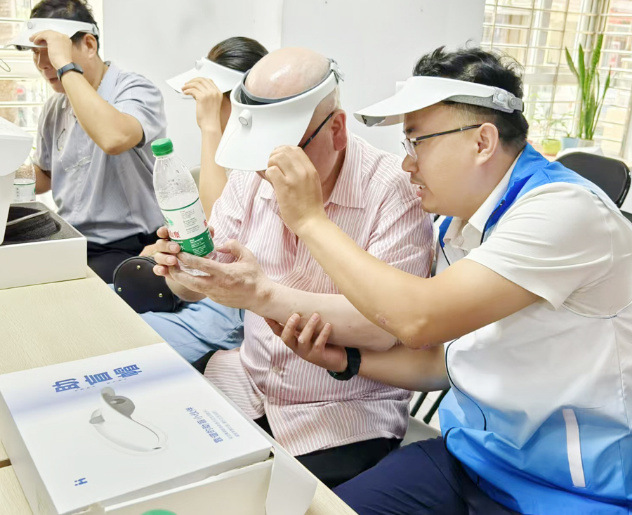 活動現(xiàn)場，輔導(dǎo)老師為視障人士講解助盲帽具。林林?jǐn)z