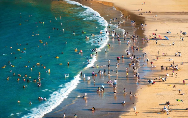 海灘上，游客正在戲水。陳肇晞攝