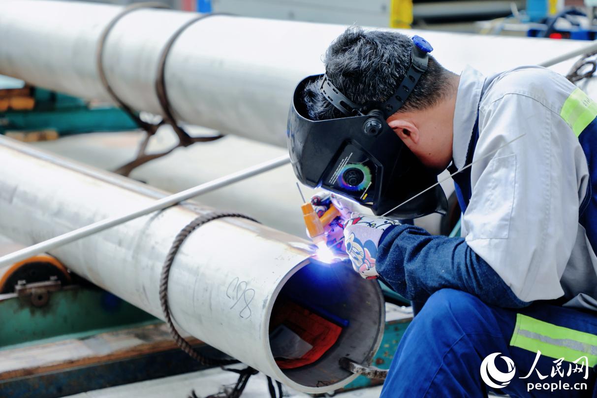 青山鋼管福建分公司車間內(nèi)，員工正在將鋼管整圓。人民網(wǎng) 李唯一攝