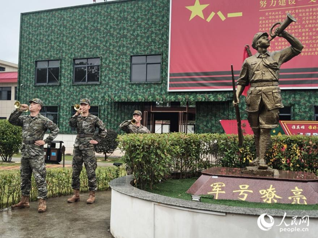 武警官兵在“軍號嘹亮”雕塑前吹奏軍號。人民網(wǎng) 楊灝昱攝