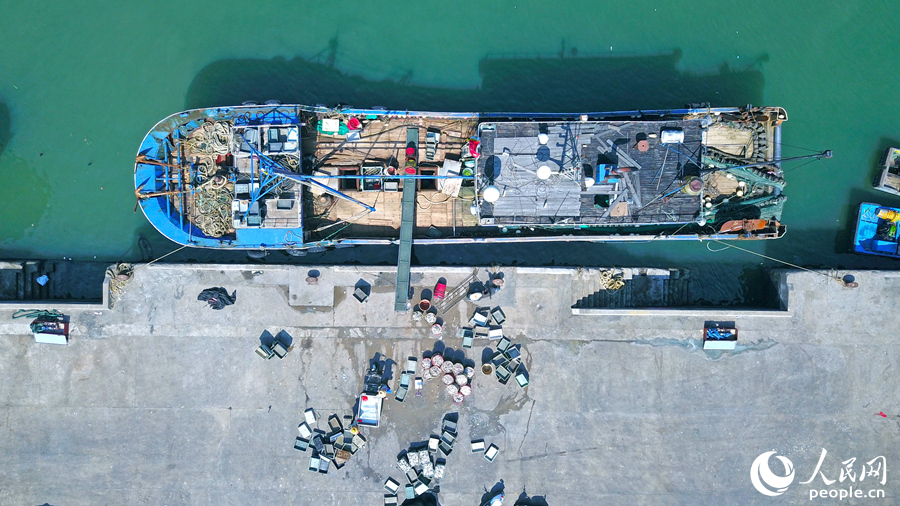 5.在澳角村，一艘漁船停在岸邊卸下漁貨。人民網(wǎng) 李昌乾攝