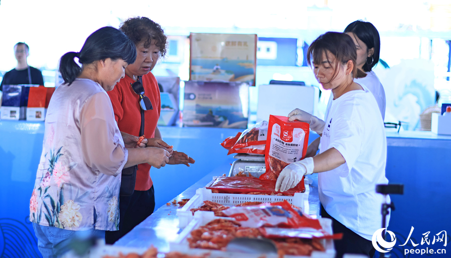 10.在澳角村，游客采購當(dāng)?shù)睾ｕr加工產(chǎn)品。人民網(wǎng) 李昌乾攝