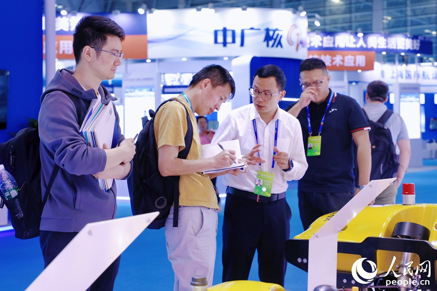 觀眾一邊同參展商交流一邊記筆記。人民網(wǎng) 李唯一攝