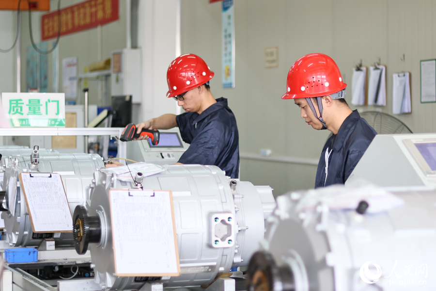 金龍新能源車間內(nèi)，技術(shù)人員進行電機電控關(guān)鍵技術(shù)組裝