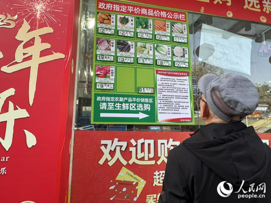 超市門口的價(jià)格公示欄標(biāo)注著當(dāng)天售賣的平價(jià)肉菜價(jià)格。人民網(wǎng)記者 張萌攝