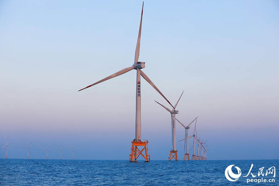 天色漸暗，“海上大風(fēng)車”被霞光映襯著。人民網(wǎng) 李唯一攝