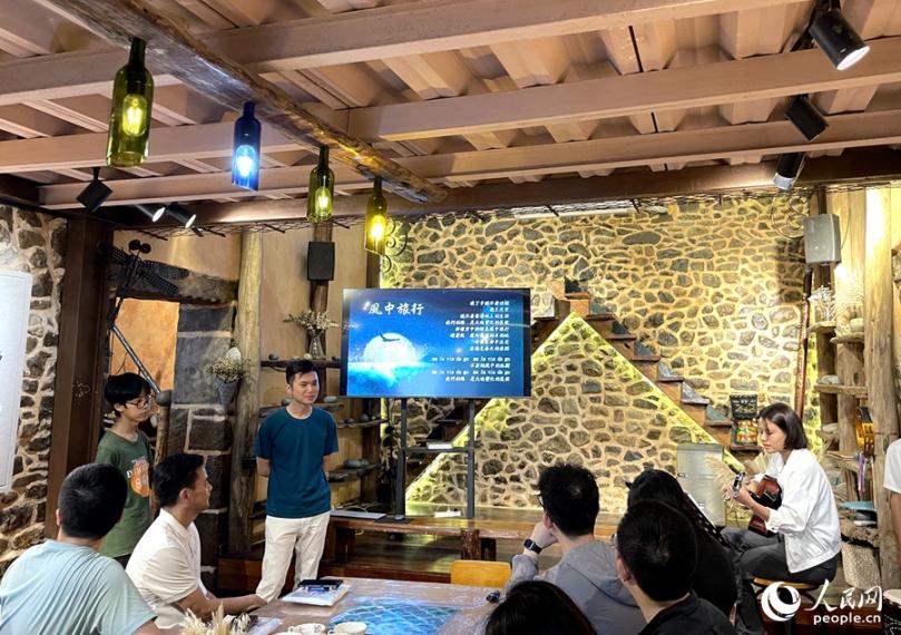 風中旅行文創(chuàng)工坊里，主理人正在用歌聲歡迎遠道而來的客人。人民網記者 陳藍燕攝