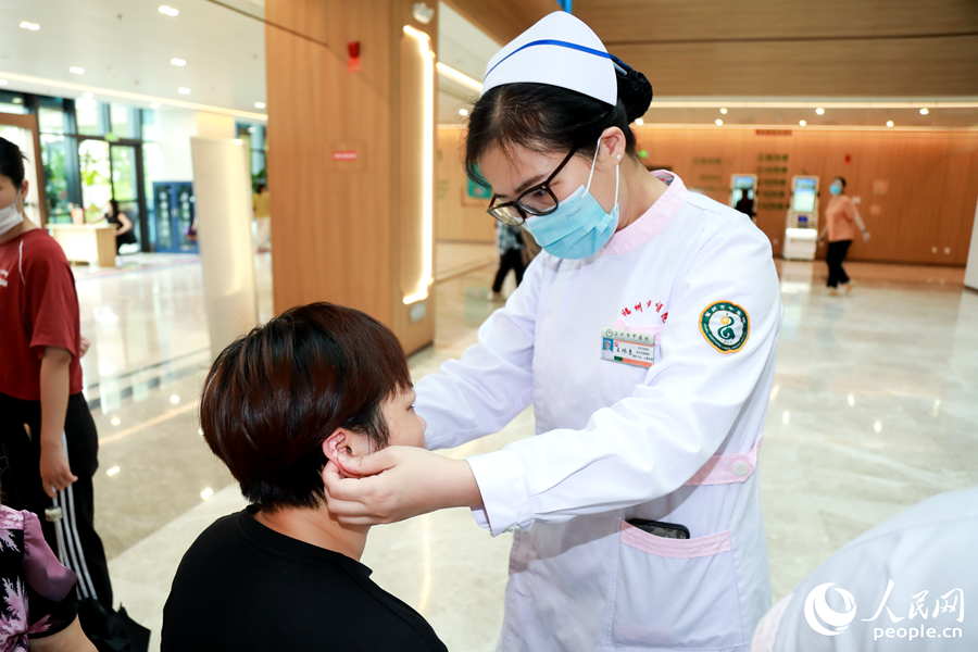 市民體驗(yàn)耳穴壓豆中醫(yī)適宜技術(shù)。人民網(wǎng) 陳永整攝