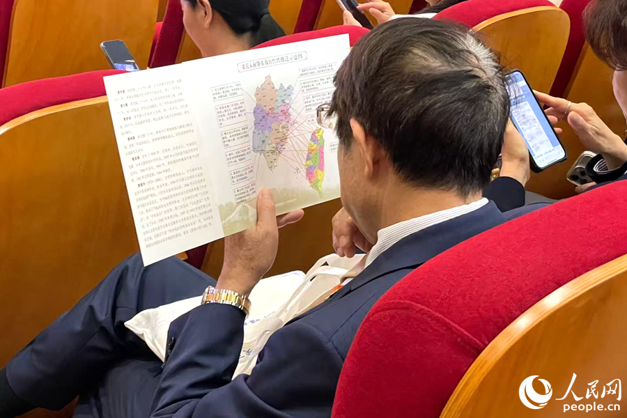 一位嘉賓認真端詳姓氏入閩及遷臺示意圖。人民網記者 林盈攝