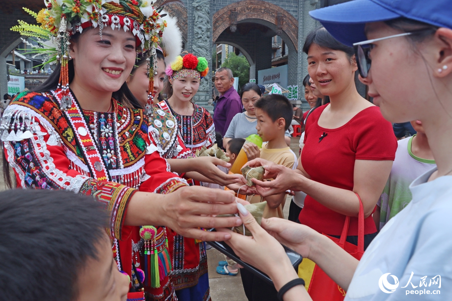 為游客免費派發(fā)“烏米粽”。人民網(wǎng) 李昌乾攝