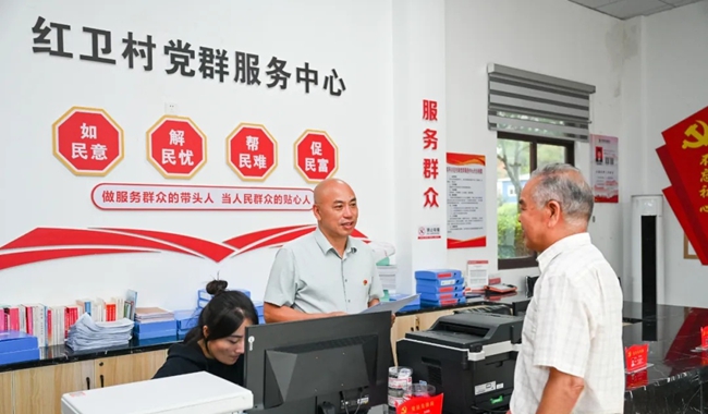 在紅衛(wèi)村黨群服務(wù)中心，林希騰解答村民問題